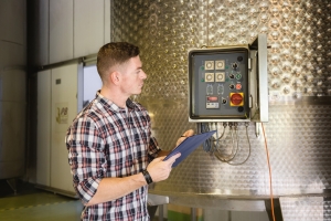 Food processing electrical contractor inspecting industrial control equipment.