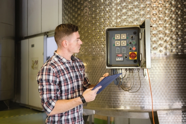 Food processing electrical contractor inspecting industrial control equipment.